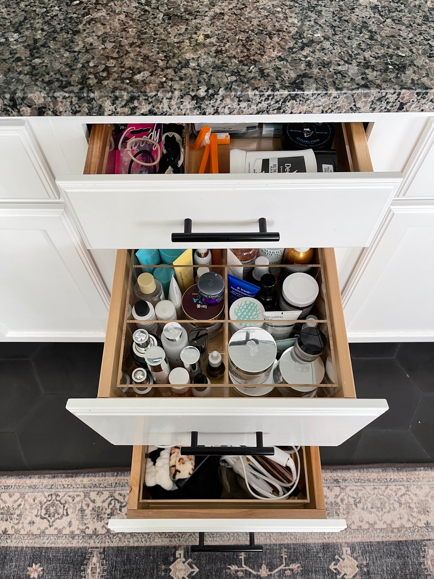 Three open drawers all organized with acrylic custom-fit organizers.