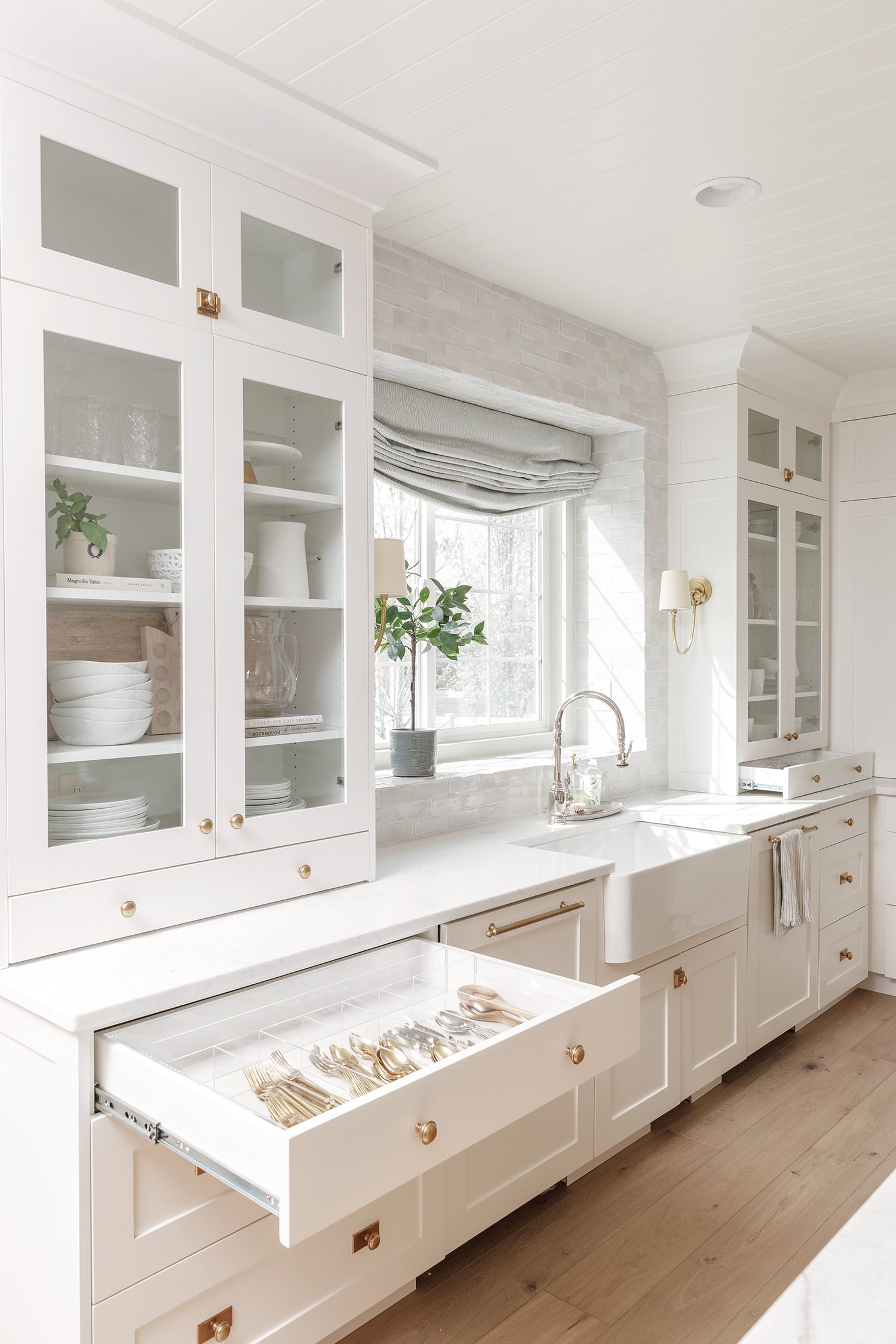 Bright white kitchen with one drawer pulled out displaying a custom-fit organizer.