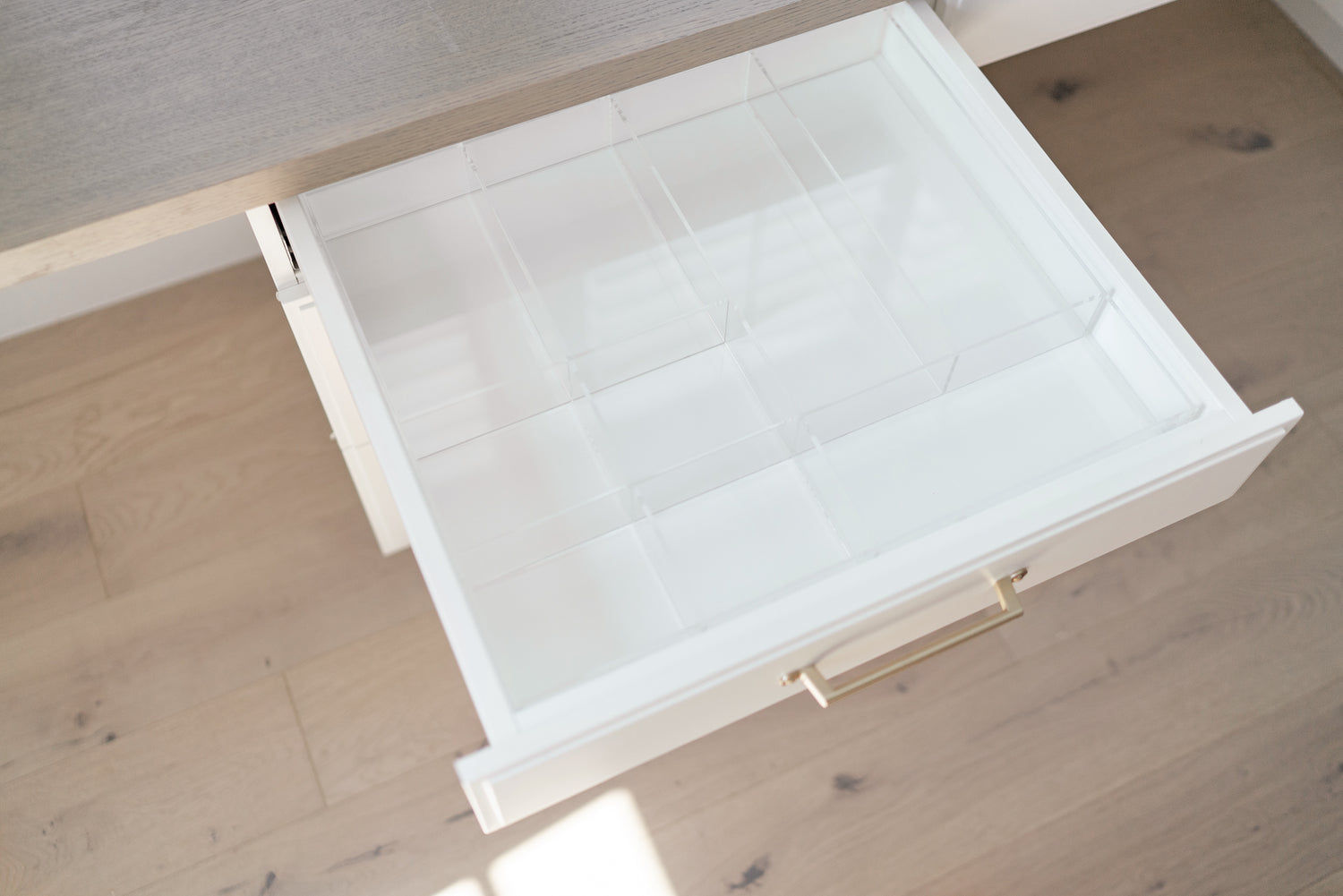 Open drawer with a crystal clear, acrylic custom-fit drawer organizer.