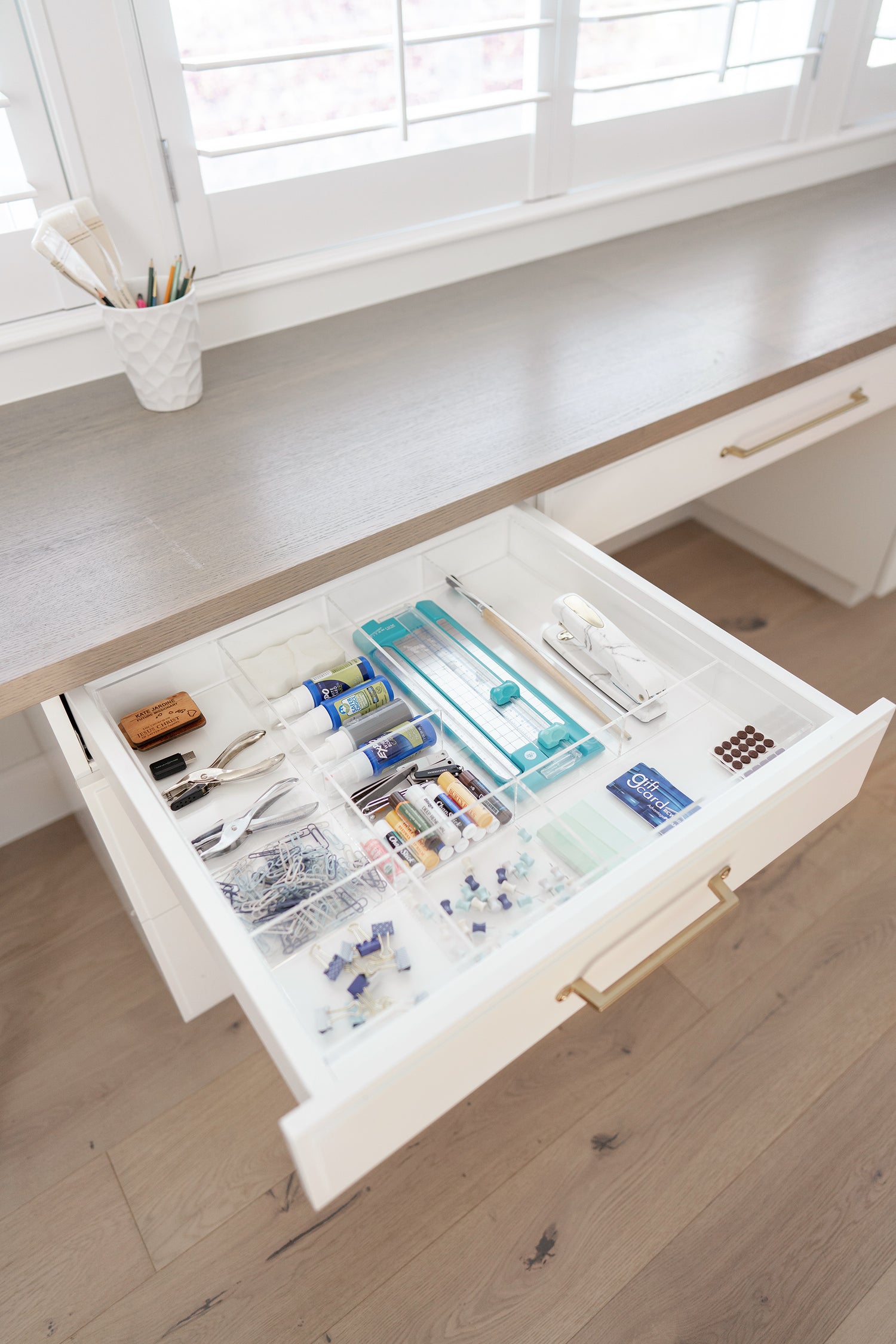 Open craft drawer with a variety of supplies kept tidy with a custom-fit organzier.