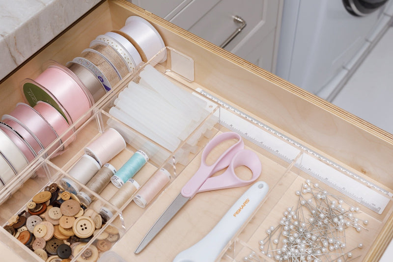 Close-up view of an acrylic Expandable Organizer containing a variety of craft supplies.