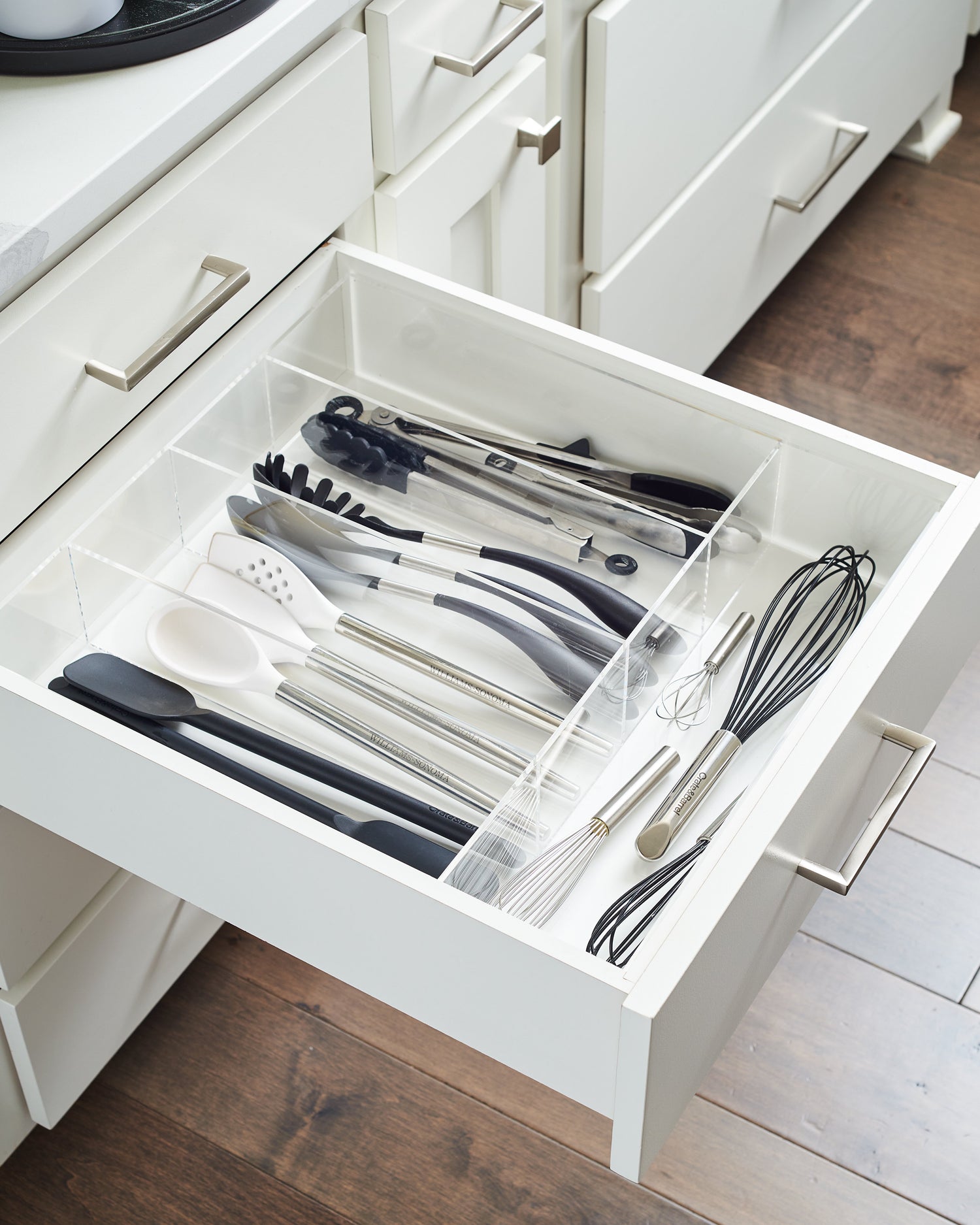 Side view of a kitchen utensil drawer perfectly put together with a custom-fit drawer organizer.  