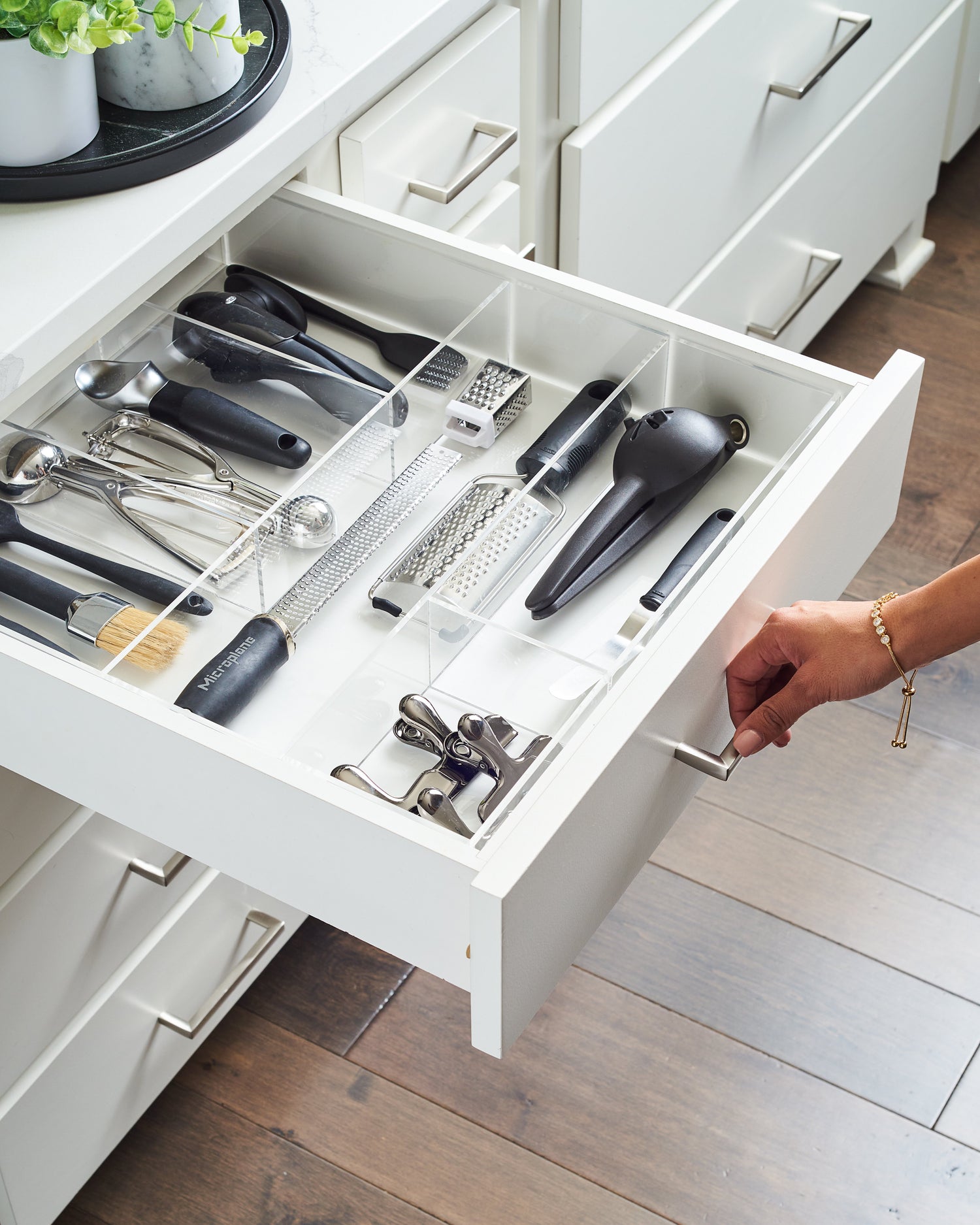 An individual opening their perfectly organized kitchen utensil drawer. 