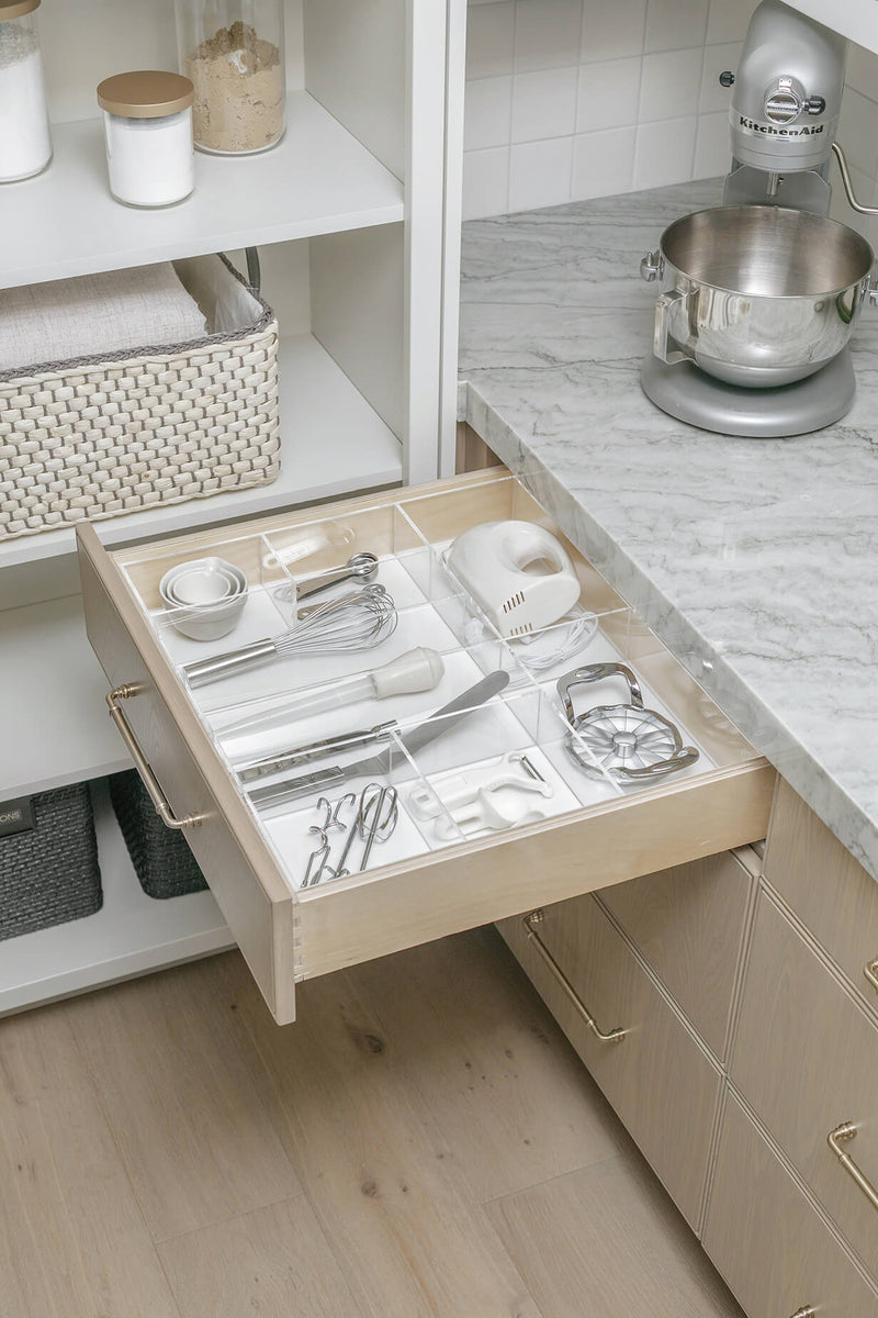 Open kitchen drawer with kitchen tools contained in an acrylic organizer.