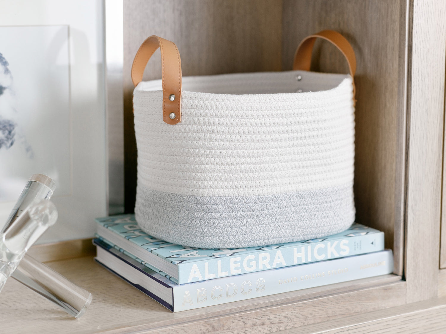 The Santorini basket with white and gray fabric and leather handles makes a beautiful addition to this open shelf.