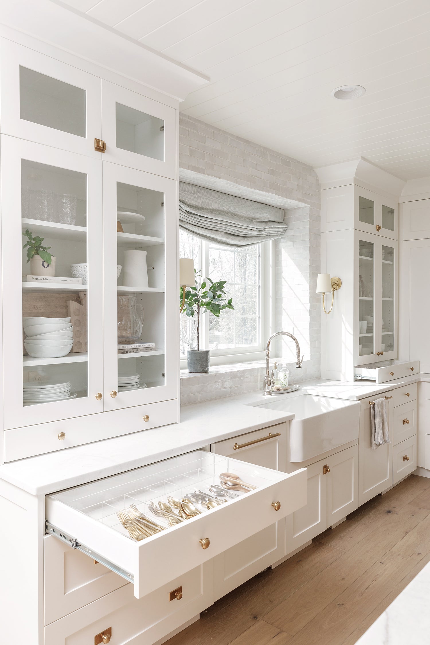 Bright white kitchen with one drawer pulled out displaying a custom-fit organizer. 