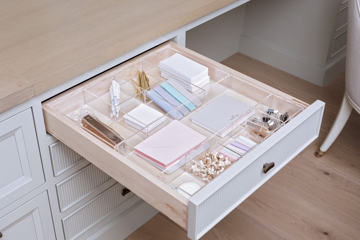 Stunning, organized office drawer containing notepads, pushpins, and pens among other items. 