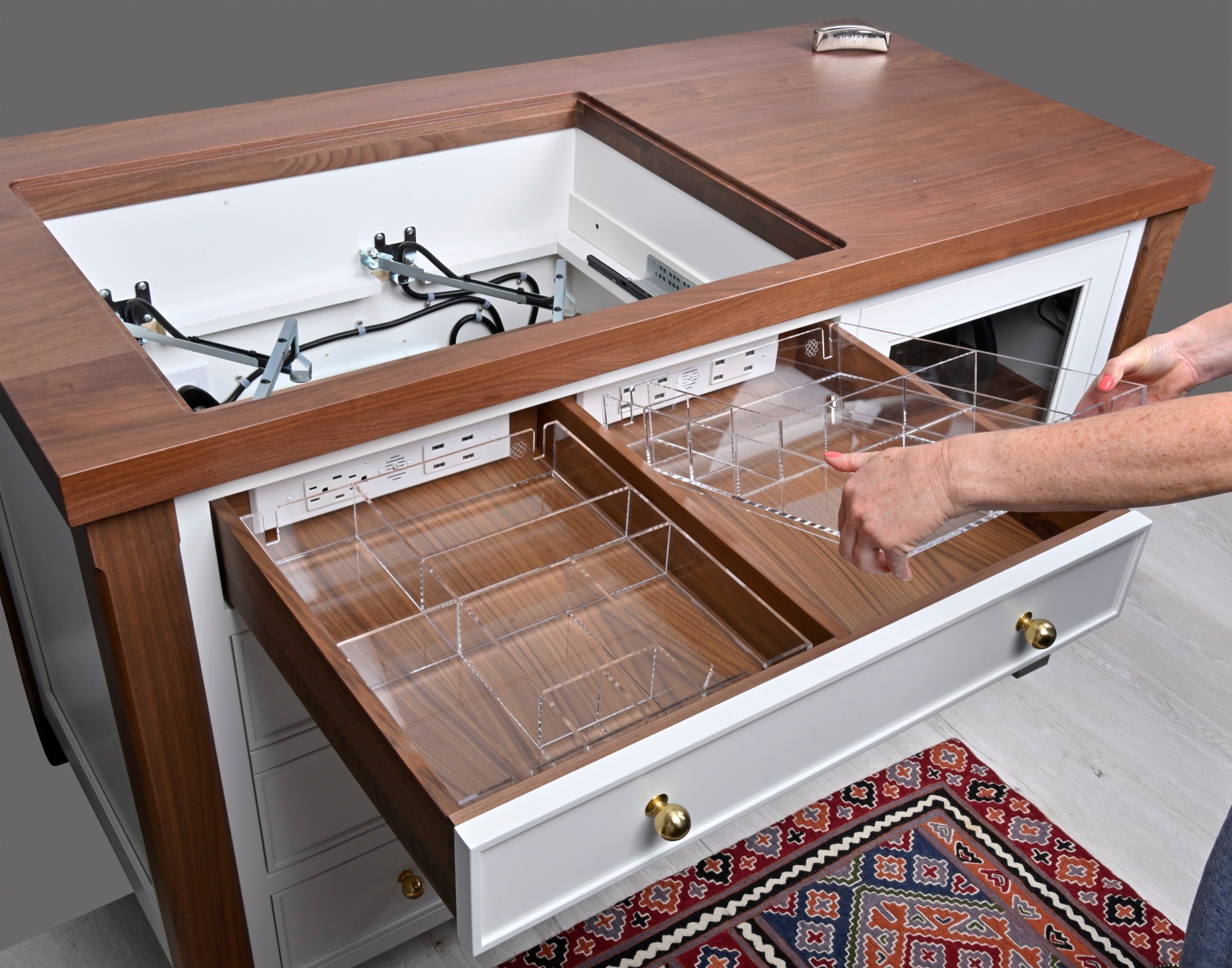 Custom-fit organizers in an open drawer with designated space for in-drawer charging cords.