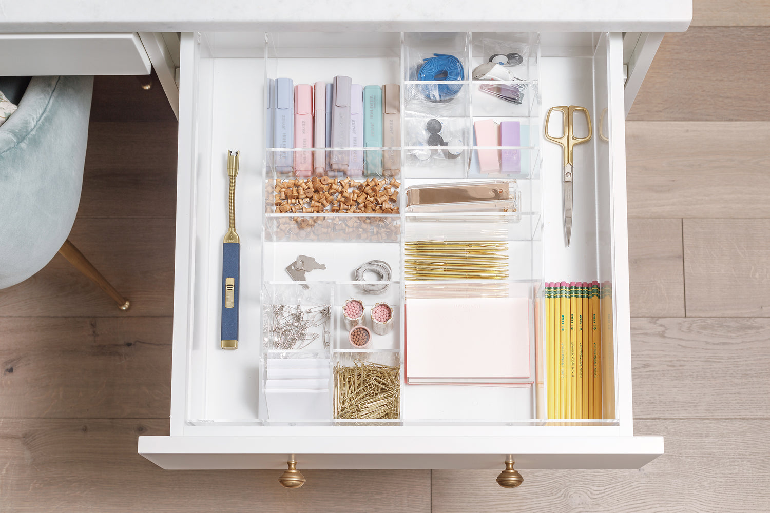 Perfectly organized drawer full of office supplies including pencils, notepads, and paper clips.