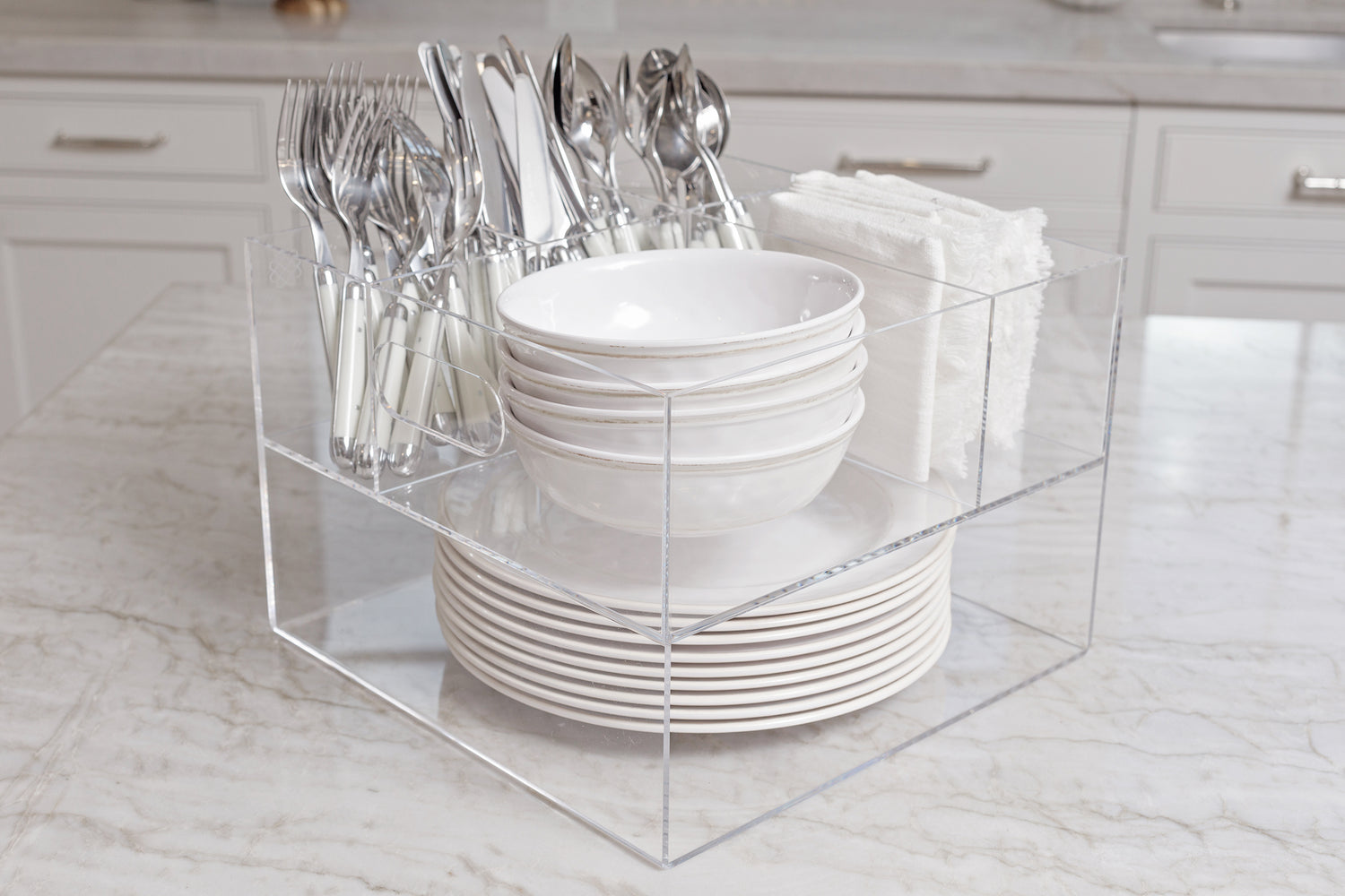 White dishes, silverware, and linen napkins stocked and ready to serve in the Acrylic Utensil Caddy.
