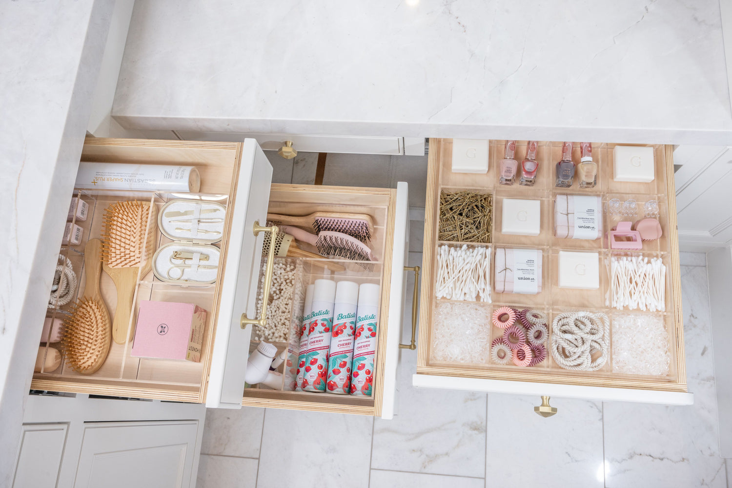 Three bathroom drawers opened to show each perfectly organized with a Custom-fit Acrylic Organizer.