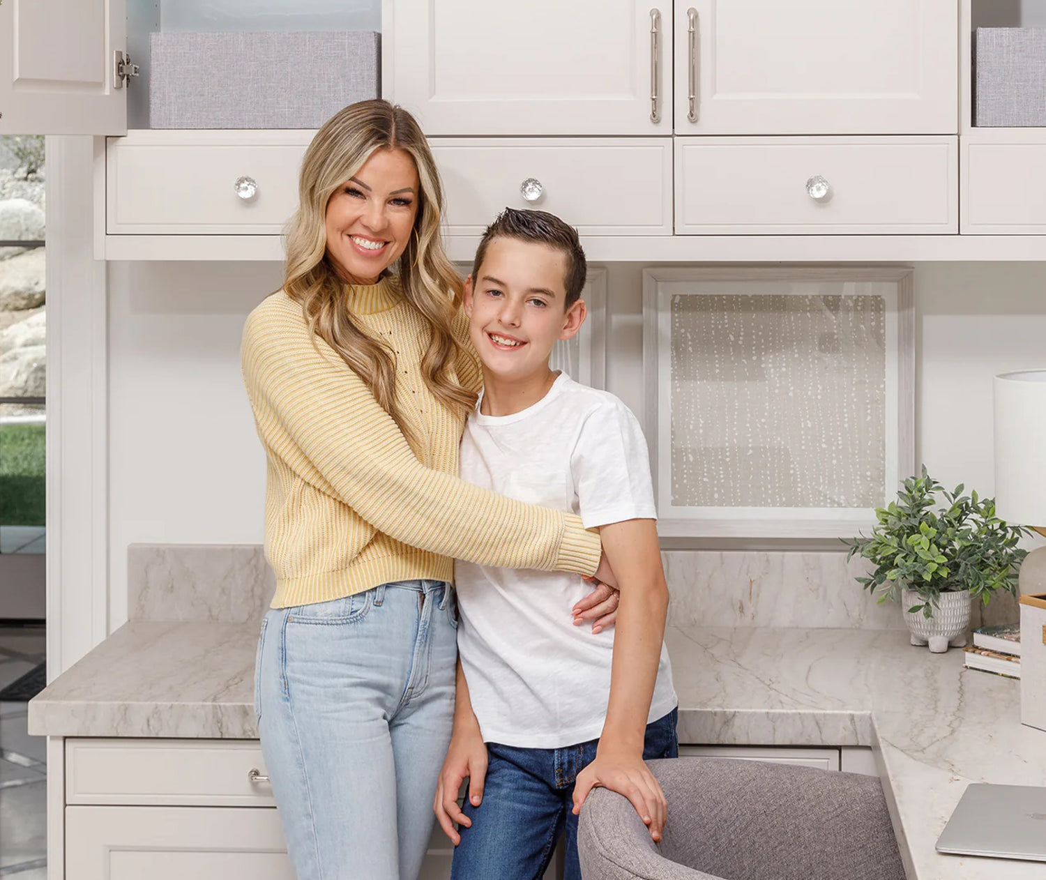 Sabrina with her son in their kitchen desk area. 
